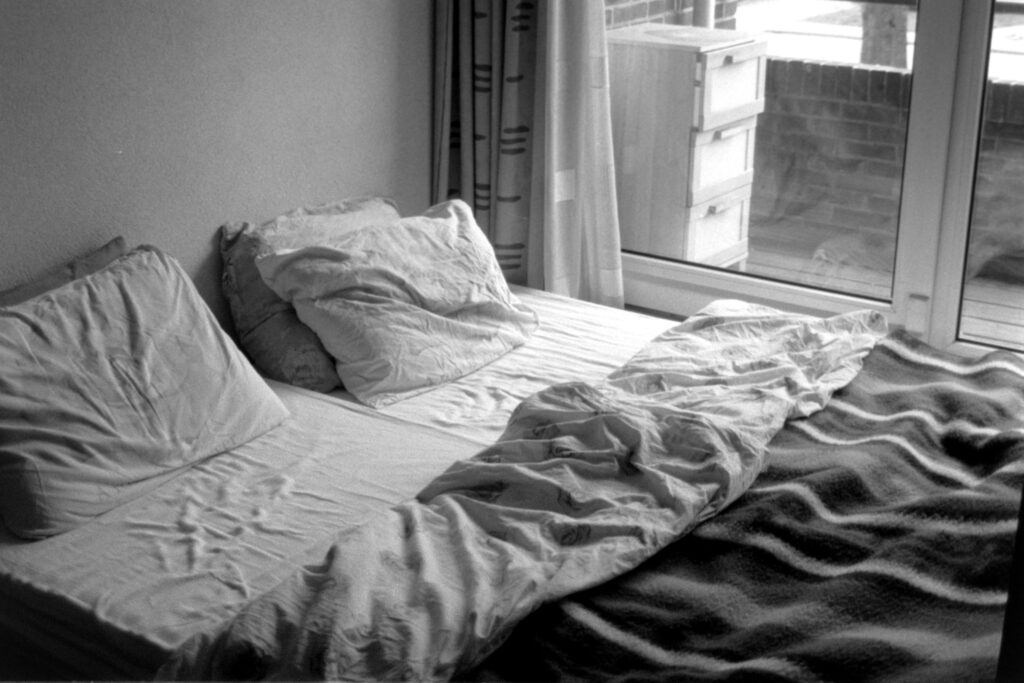 elhaaim-mbvHui7I5KQ-unsplash A rumpled bed in soft daylight, symbolizing exhaustion and disrupted sleep from burnout.